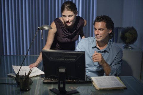 Man and woman working late in office.