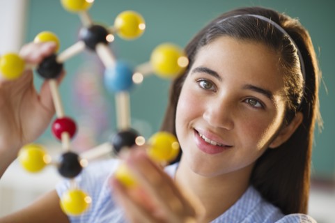 Schoolgirl (12-13) looking at molecular model.