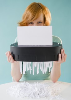 Young woman shredding paper. Photo : Jamie Grill