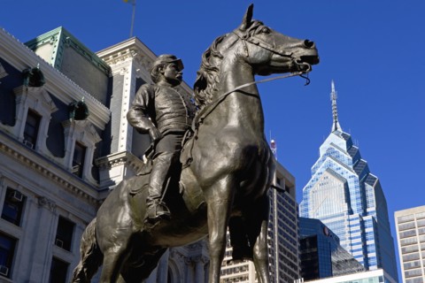USA, Pennsylvania, Philadelphia, Statue depicting man on horse, skyscrapers in background. Photo :