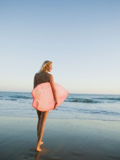 Portrait of woman with surfboard.