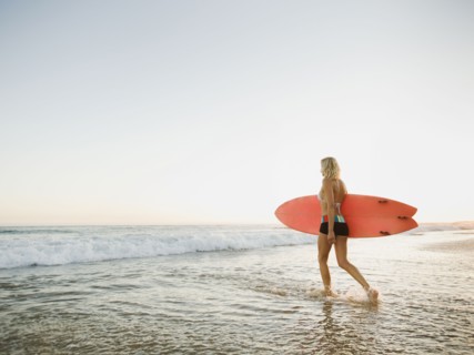 Portrait of woman with surfboard.