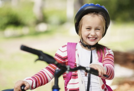 Smiling girl (10-11) with bicycle. Photo : Momentimages