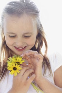 Girl (10-11) with sunflowers. Photo : Momentimages