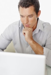 Portrait of good-looking mid adult man working on laptop. Photo : Momentimages