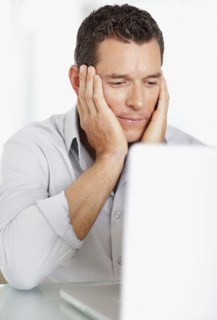 Portrait of good-looking mid adult man working on laptop. Photo : Momentimages
