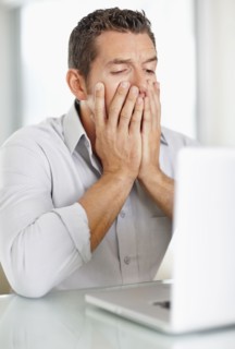 Portrait of good-looking mid adult man working on laptop. Photo : Momentimages