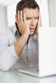Portrait of good-looking mid adult man working on laptop. Photo : Momentimages