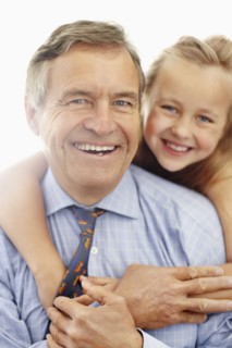 Portrait of smiling grandfather and granddaughter (10-11). Photo : Momentimages