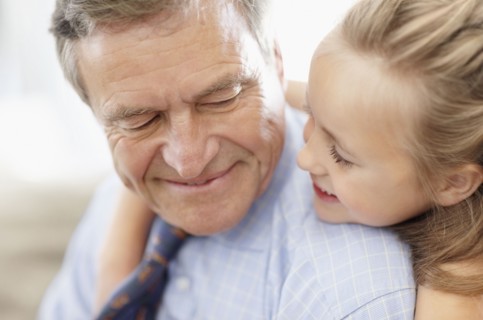 Smiling grandfather and granddaughter (10-11). Photo : Momentimages