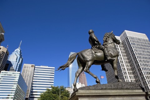 USA, Pennsylvania, Philadelphia, Statue depicting man on horse, skyscrapers in background. Photo :