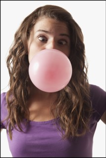 Young woman blowing bubble gum. Photo : Mike Kemp