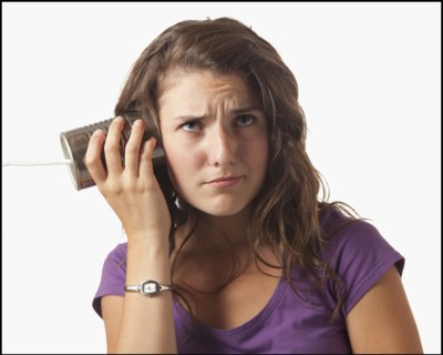 Young woman holding tin can phone. Photo : Mike Kemp