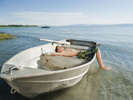 Boy (10-11) resting on boat.