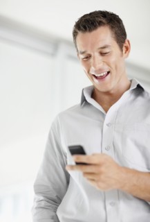 Portrait of good-looking mid adult man text messaging. Photo : Momentimages