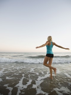 Portrait of woman running on beach.