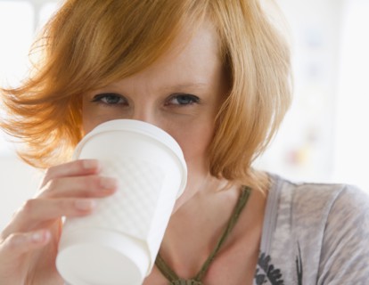 Young woman drinking from disposable cup. Photo : Jamie Grill