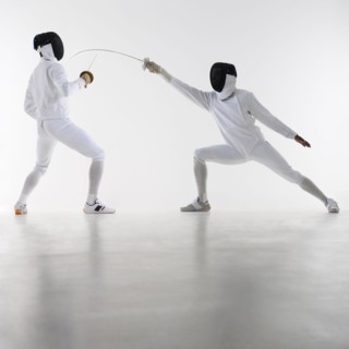 Studio shot of fencers in attacking lunge.