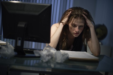 Exhausted woman working late in office.