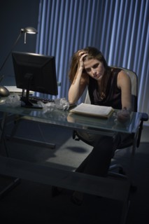 Exhausted woman working late in office.