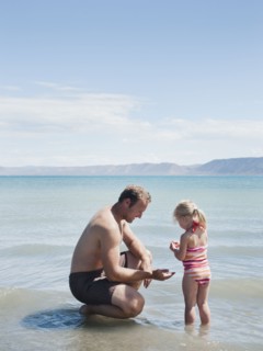 Father and daughter (2-3) at lake.
