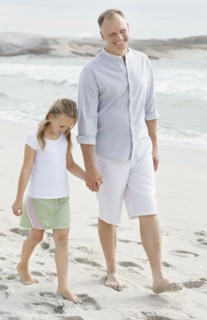 Girl (10-11) playing on beach with father. Photo : Momentimages