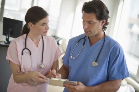 Doctors consulting documentation in hospital.