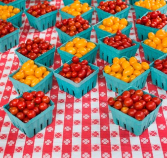 Boxes with cherry tomatoes on table.