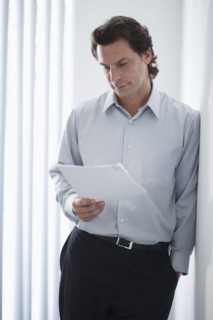 Man in office reading document.