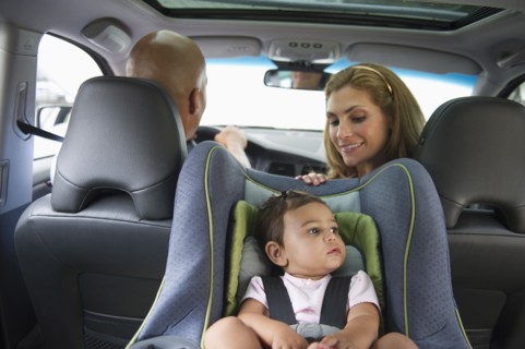 Young family with small girl (12-18 months) sitting in car.