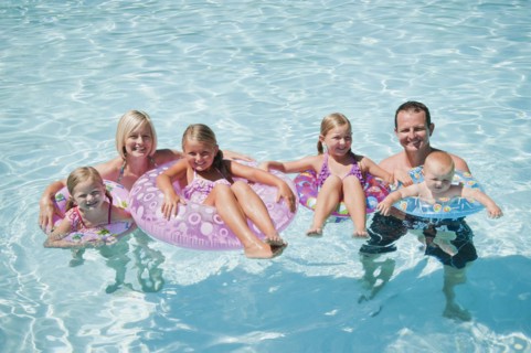 Family with four kids (12-18months, 4-5,6-7,8-9) on swimming pool.