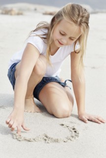Girl (10-11) playing on beach. Photo : Momentimages