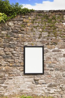 Blank sign on stone wall . Photo : Jon Boyes