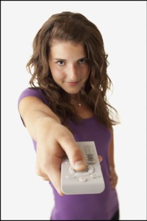 Young woman holding remote control. Photo : Mike Kemp