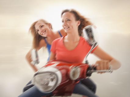 Young girls (16-17) riding scooter. Photo : Mike Kemp