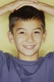 Cute young boy with his hands on his head. Photo : Fisher Litwin