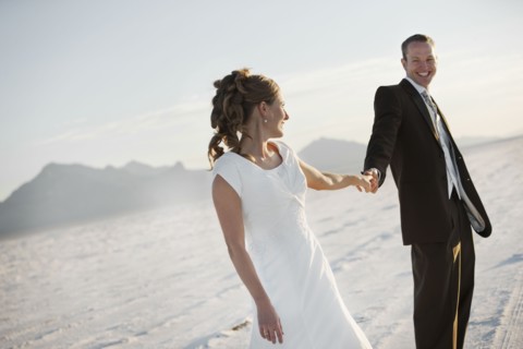 Bride and groom holding hands in desert. Photo : FBP
