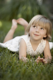 Girl (2-3) lying on grass. Photo : FBP