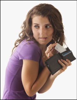 Young woman removing banknote from wallet. Photo : Mike Kemp