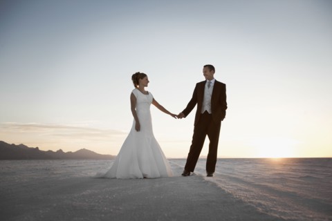 Bride and groom holding hands in desert. Photo : FBP