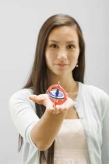 Studio portrait of young woman holding gyroscope. Photo : FBP