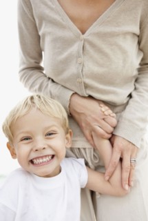 Portrait of boy (4-5) holding mother hand and making face. Photo : Momentimages