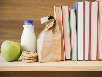 Row of books and lunch bag on shelf. Photo : Jamie Grill