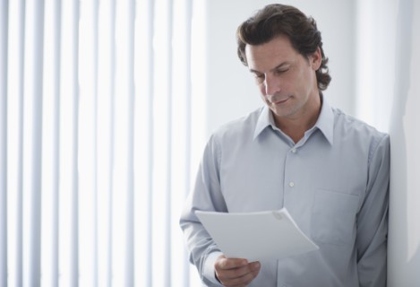 Man in office reading document.