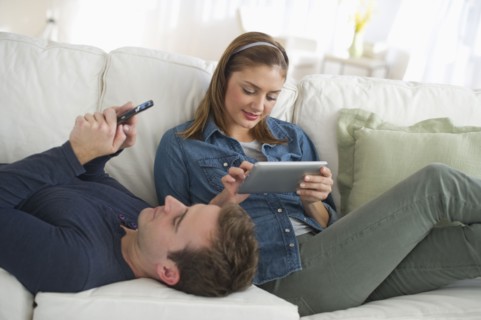 USA, New Jersey, Jersey City, Portrait of young couple relaxing on sofa.