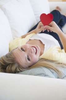 USA, New Jersey, Jersey City, Attractive young woman holding red heart. Photo : Jamie Grill