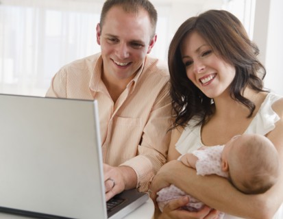 USA, New Jersey, Jersey City, family with baby daughter (2-5 months) sitting in front of laptop.