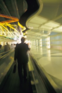 USA, Colorado, Businessman walking through airport, blurred motion. Photo : John Kelly