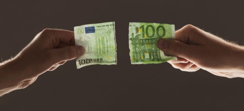 Hands holding torn one hundred euro note. Photo : Mike Kemp