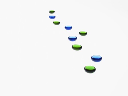 Studio shot of blue and green glass beads in row. Photo : David Arky